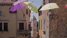 umbrellas against a blue sky and a historic church