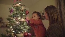 mother and son decorating a Christmas tree