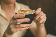 woman holding a cup of cappuccino 