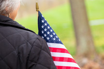 Close up behind woman holding american flag