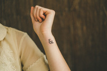 woman with an & tattoo on her wrist