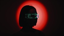 Girl with futuristic glasses on red background 
