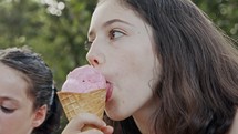Young girl eating Ice Cream from a cone, enjoying and laughing