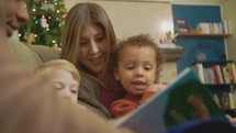 mother reading Christmas books to her children 