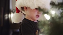 boy hanging ornaments on a Christmas tree 