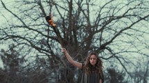 a woman holding a burning torch 