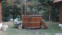 Traditional Round Wooden Hot Tub Outside The House. - wide shot