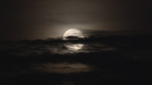 The moon rising with clouds in front