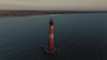 A lighthouse on the  Atlantic Ocean coast of South Carolina during sunrise 