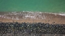 Aerial View of Waves Coming onto a Sandy Beach with Boulders - County Wicklow