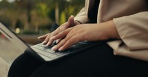 Young business woman walking around the city using her phone and laptop