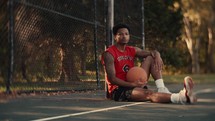 Portrait of a smiling young man playing basketball on a sunny day