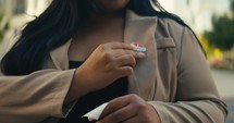 Young woman smiling with an ‘I Voted’ stickers and pin 