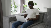Black man works at a laptop, makes video conferences or video call.
