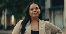 Young woman smiling with an ‘I Voted’ stickers and pin 