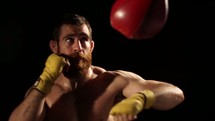 man boxing, punching a punching bag