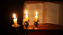 candles and pages of a Bible 