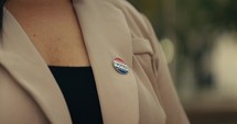 Young woman smiling with an ‘I Voted’ stickers and pin 