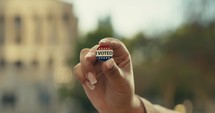 Young woman smiling with an ‘I Voted’ stickers and pin 