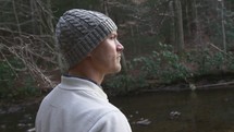 man standing by a creek 