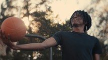 Portrait of a smiling young man playing basketball on a sunny day