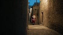 Santa Claus around a village on Christmas night 