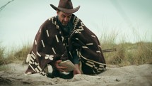 Man digs with his hands in the sand