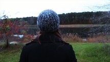 a woman standing looking out at a river 