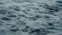 Water running over the sand of a tropical beach at dusk