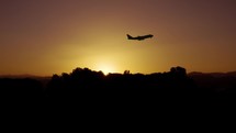 Silhouette of Airplane Take Off At Sunset