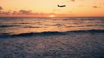 Silhouette of Airplane Take Off On The Ocean At Sunset