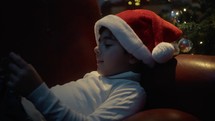Child enjoying videogame under the Christmas tree 