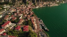 drone flying over old town with church on lake garda