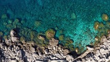 Aerial view of a cliff on a clear sea in Summer
