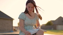 Girl Reading Bible Outside at Sunset