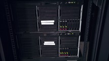 Close up shot of data servers with ethernet cables and blinking hard drive lights