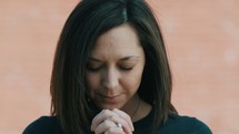 slow motion of a woman bowing in prayer