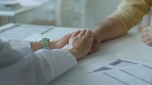 Hands of Caring Female Doctor Supporting Patient at Clinic
