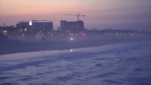 Overlooking Huntington beach waves and buildings early morning.