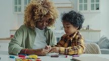 Preschool Kid and His Mother Drawing Together on Paper at Home
