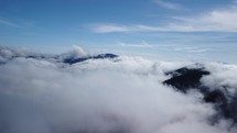 cloudy landscape. Aerial view over clouds in hilly landscape,  blue sky