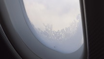 Close up of a frozen commercial airplane window.