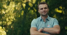 Young man smiling with an ‘I Voted’ sticker and pin 