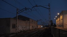 Train coming in through graffiti buildings