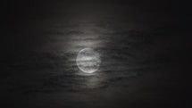 Moon slowly rising with clouds in front of it