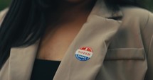 Young woman smiling with an ‘I Voted’ stickers and pin 