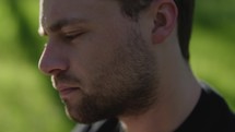 Young man reading his Bible outside on a warm sunny day