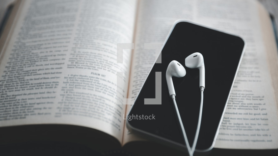Earbuds and phone on a Bible