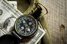 compass and cash on a green bag 