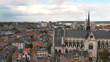 Fly-over pan across Leuven Saint Peter's Church to Town Hall, Belgium